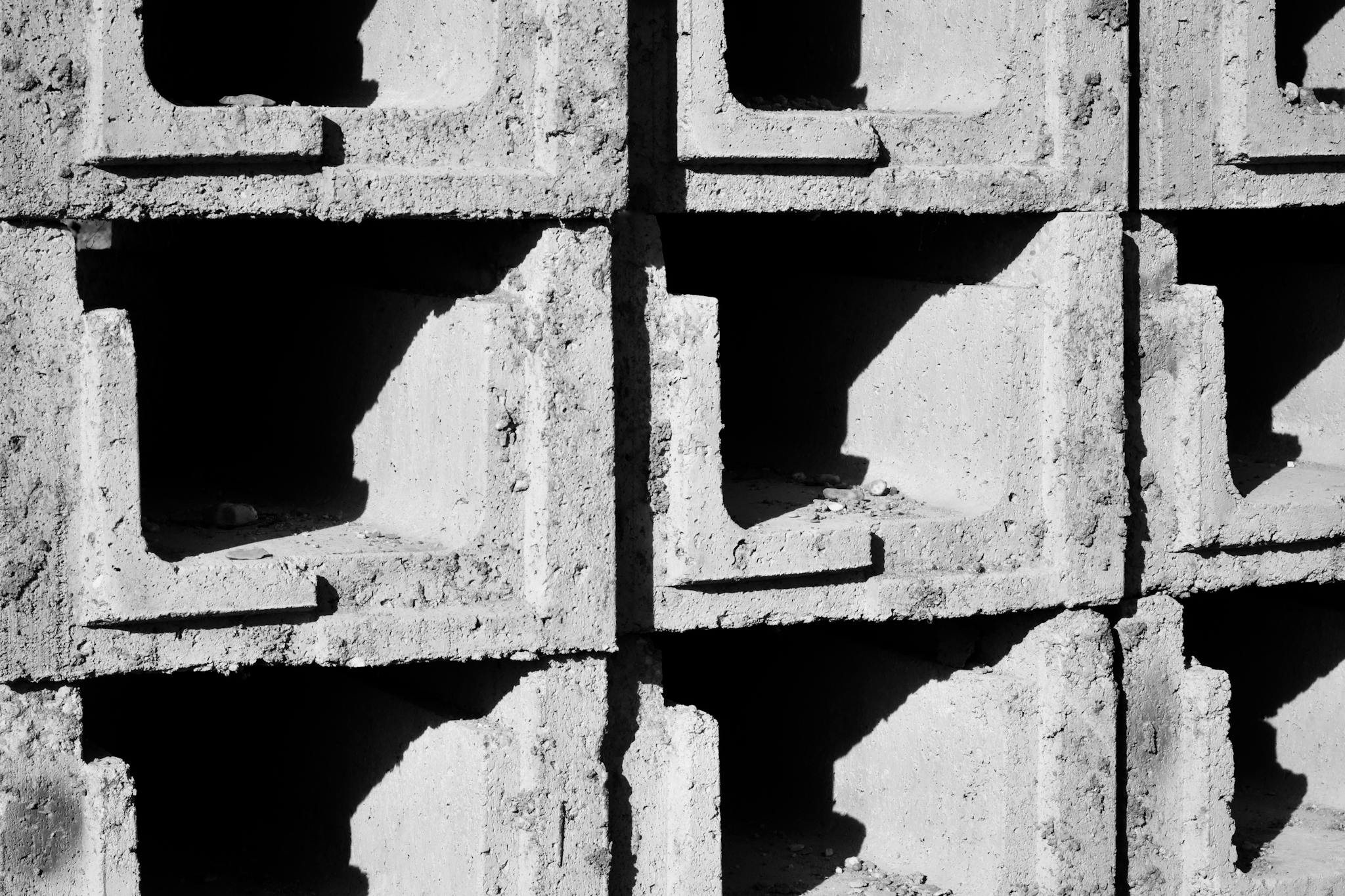 Detailed view of textured concrete blocks casting shadows in bright sunlight.